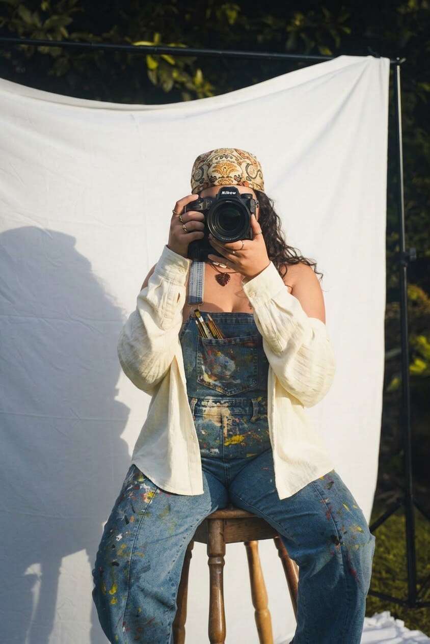 Fotógrafa de RONI Creative Studio con su cámara frente a un fondo blanco, durante una producción de contenido.