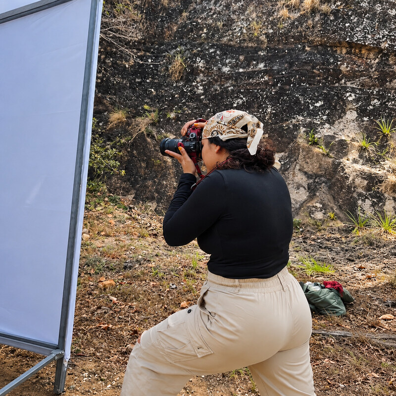 Fotógrafa de RONI Creative Studio frente a un rebote blanco durante una producción en locación.